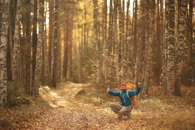 follow me on a hike, a man invites you to a forest hike, autumn landscape in the forest in nature