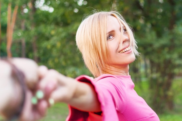 Seguimi una donna con un vestito rosa guida un uomo d'estate