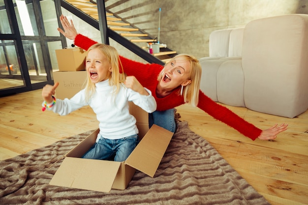 Follow us. Cute young woman feeling happiness while sitting near her daughter