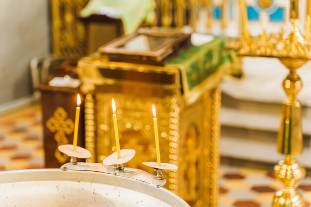 Купель и 3 зажженные свечи с водой в церкви на Богоявление