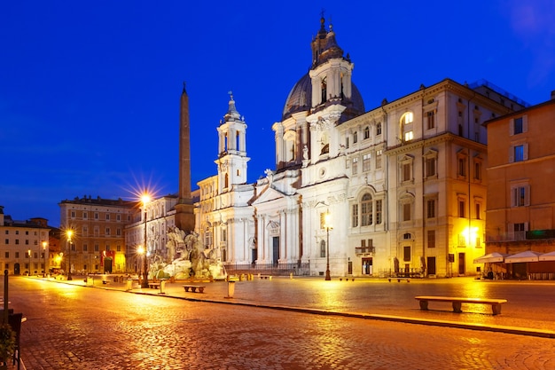 Fontein van de vier rivieren met een Egyptische obelisk en de Sant Agnese-kerk op het beroemde Piazza Navona-plein 's nachts, Rome, Italië.