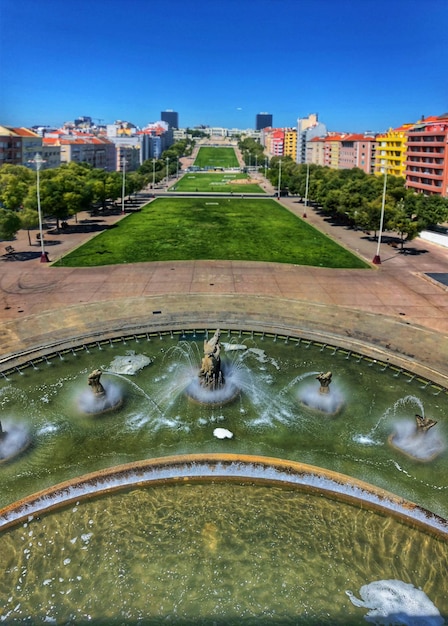 Foto fonteinen bij het park in de stad tegen een heldere blauwe hemel