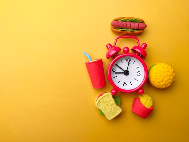 Food and alarm clock on a yellow background with copy and text space Health and medical concept