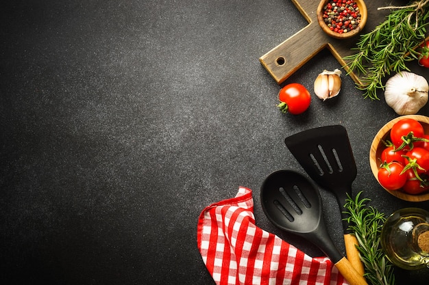 Photo food background kitchen utensils wooden cutting board and food ingredients on black top view with copy space