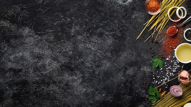 Food background for menu with spices and culinary ingredients on a dark stone background. Cooking Concepts. Culinary background. Top view. Free space for your text.