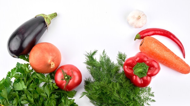 Food background. Seasonal vegetables and greens on a white table. Top view, flat lay