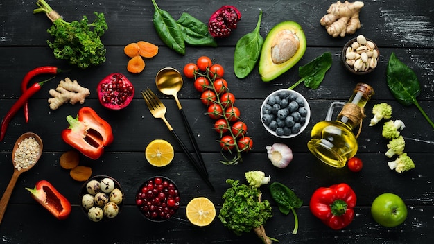 Food background A set of healthy and clean food  vegetables fruits fish meat nuts and greens On a black stone background Top view Free copy space