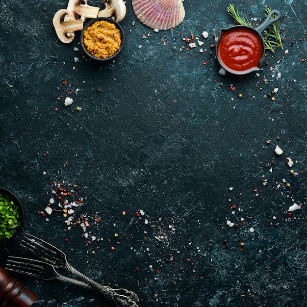 Food background Spices and herbs on black stone background Top view