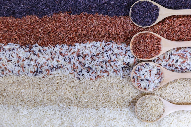 Food background with top view of five rows of rice in a wooden spoon.