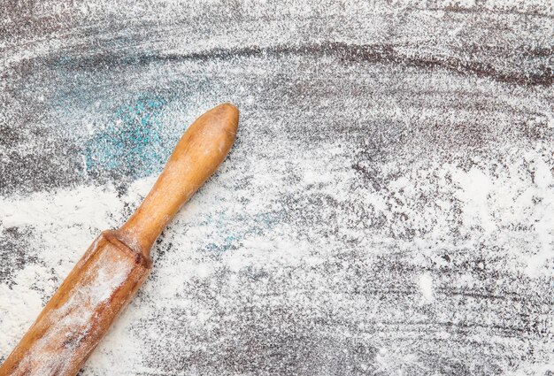 Photo food or baking background white flour sprinkled on dark table rustic wooden rolling pin with inscription baking top view