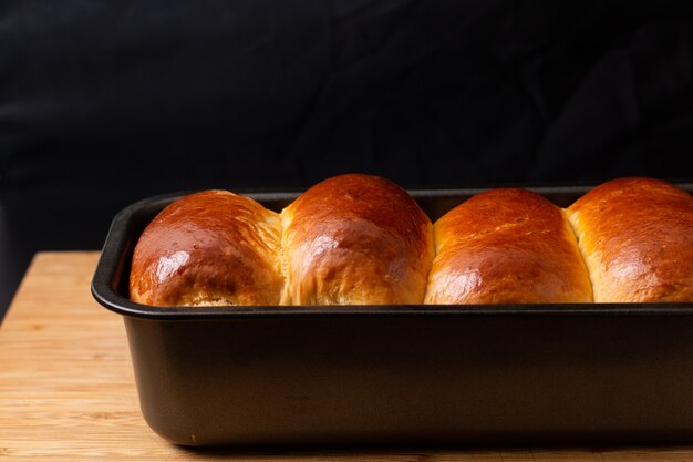 Food Baking concept Fresh baked organic homemade soft milk loaf bread in loaf pan on wooden board with copy space