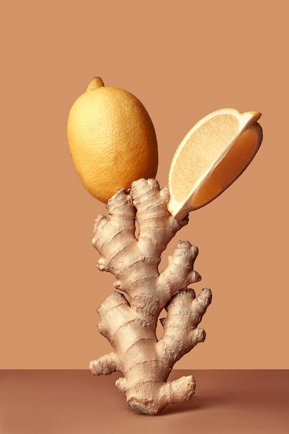 Food balance and levitation. ginger and lemon stand one on one.\
balance of fruits on a brown background.