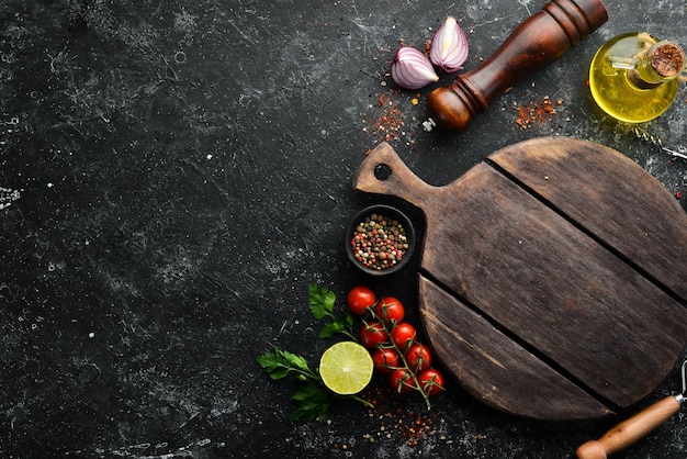 Food banner Spices vegetables and herbs on a black stone background Top view free space for your text Rustic style