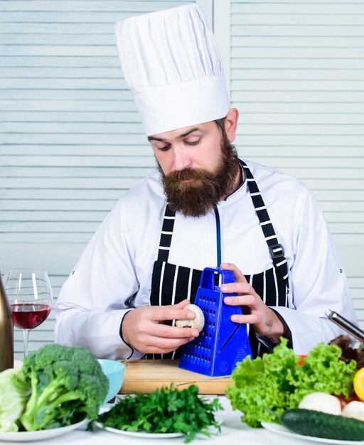 Food blogger chef-kok met hoed geheime smaakrecept dieet- en biologische voeding vitamine vegetarische volwassen chef-kok met baard gezonde voeding koken bebaarde man kok in culinaire keuken