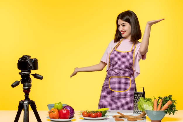 Food blogger cute fitness cook recording video for social media waving hands and starting to cook