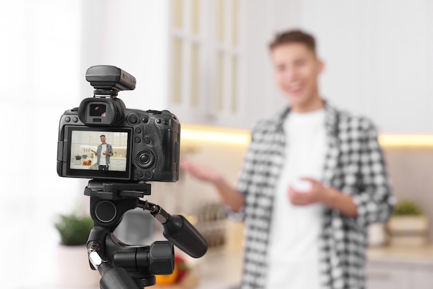 Food blogger recording video in kitchen focus on camera