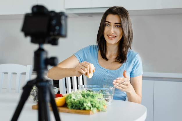 Photo food blogger woman record video at home in kitchen talking about healthy lifestyle and food