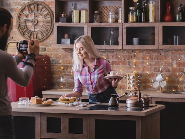 Photo food blogging business. couple lifestyle. man shooting woman with fresh homemade pastries assortment.