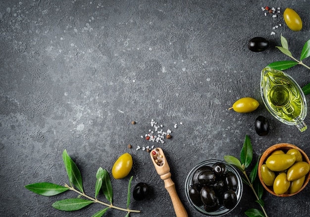 Photo food border background of green and black olives with branches. top view, copy space.