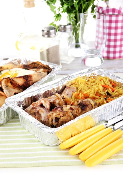 Food in boxes of foil on tablecloth