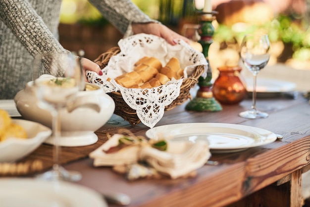 Food bread and party with hands of woman at dinner table for hospitality holiday or celebration Culinary decoration and lunch with girl serving for feast health and festive nutrition in outdoor