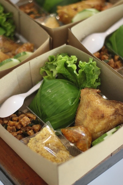 food catering fried chicken box rice with vegetables and fresh vegetables