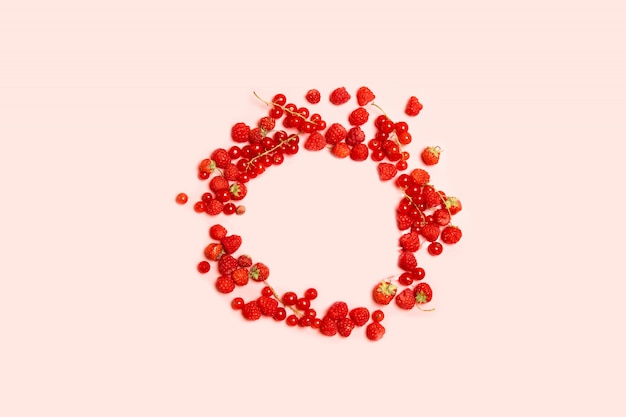 Food circle frame of red ripe currants, strawberries and raspberries