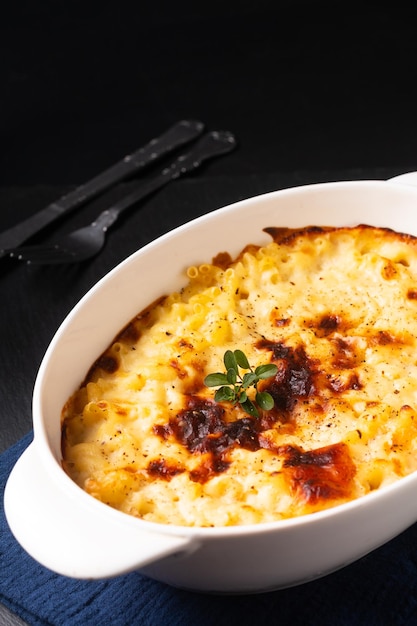 Photo food concept baked homemade mac and cheese on black slate stone board with copy space