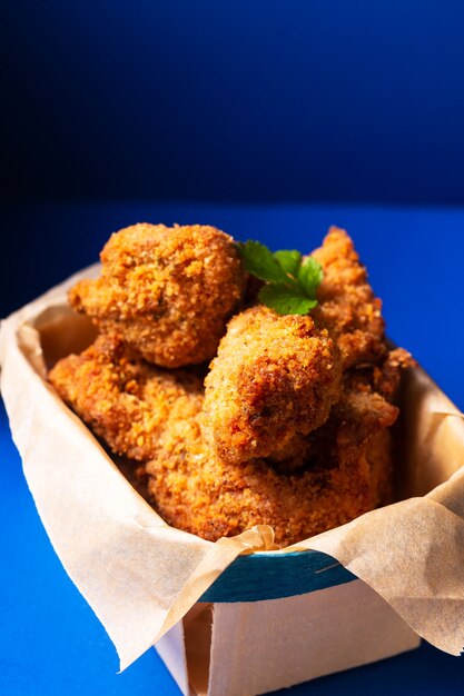 Food concept homemade herbs Crispy Fried Chicken Tenders in wooden tray with copy space