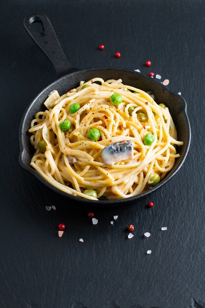 Salsa bianca cremosa degli spaghetti casalinghi di concetto dell'alimento in padella della padella della ghisa