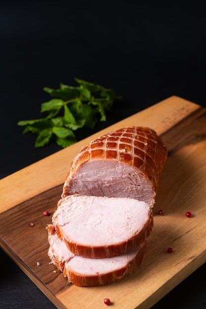 Food concept organic turkey or chicken cured ham German Kassler or Kasseler on wooden board with copy space