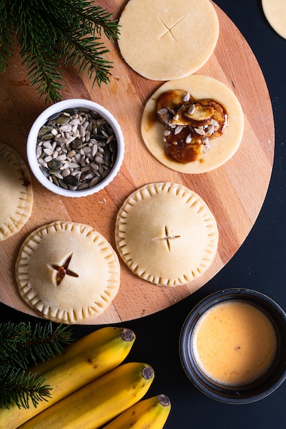 Food concept processing to make Homemade Banana foster hand pie on black