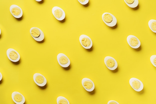 Food concept with boiled eggs pattern on yellow background