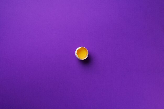 Food concept with one white egg on violet background