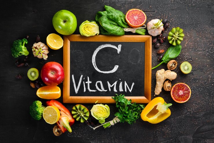 Food containing vitamin C: Orange, lemon, apple, rose, garlic, broccoli, apple, kiwi, spinach. Top view. On a brown background.