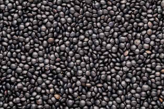 Food and cookery background of healthy dried  black lentils.