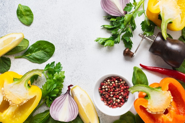 Food cooking background on white wooden table. Fresh vegetables, spices, herbs and oil.