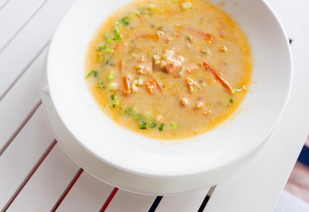 food, culinary, cooking, kitchen and eating concept - close up of cream soup plate on table at restaurant