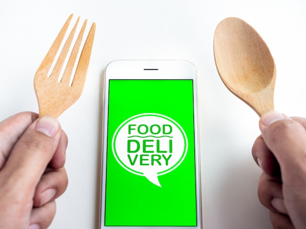 음식 배달 개념. 스마트 폰 화면에 "FOOD DELIVERY"라는 단어가 표시됩니다. 스마트 폰 기술로 음식 주문.
