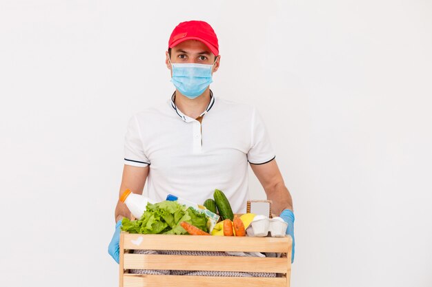 Uomo delle consegne di cibo con borse in una maschera protettiva sul viso