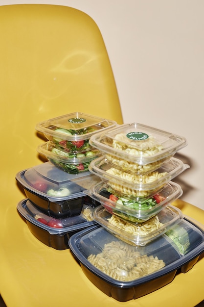 Food delivery order in plastic containers on yellow