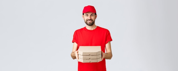 Food delivery quarantine stay home and order online concept smiling nice bearded courier in red unif...