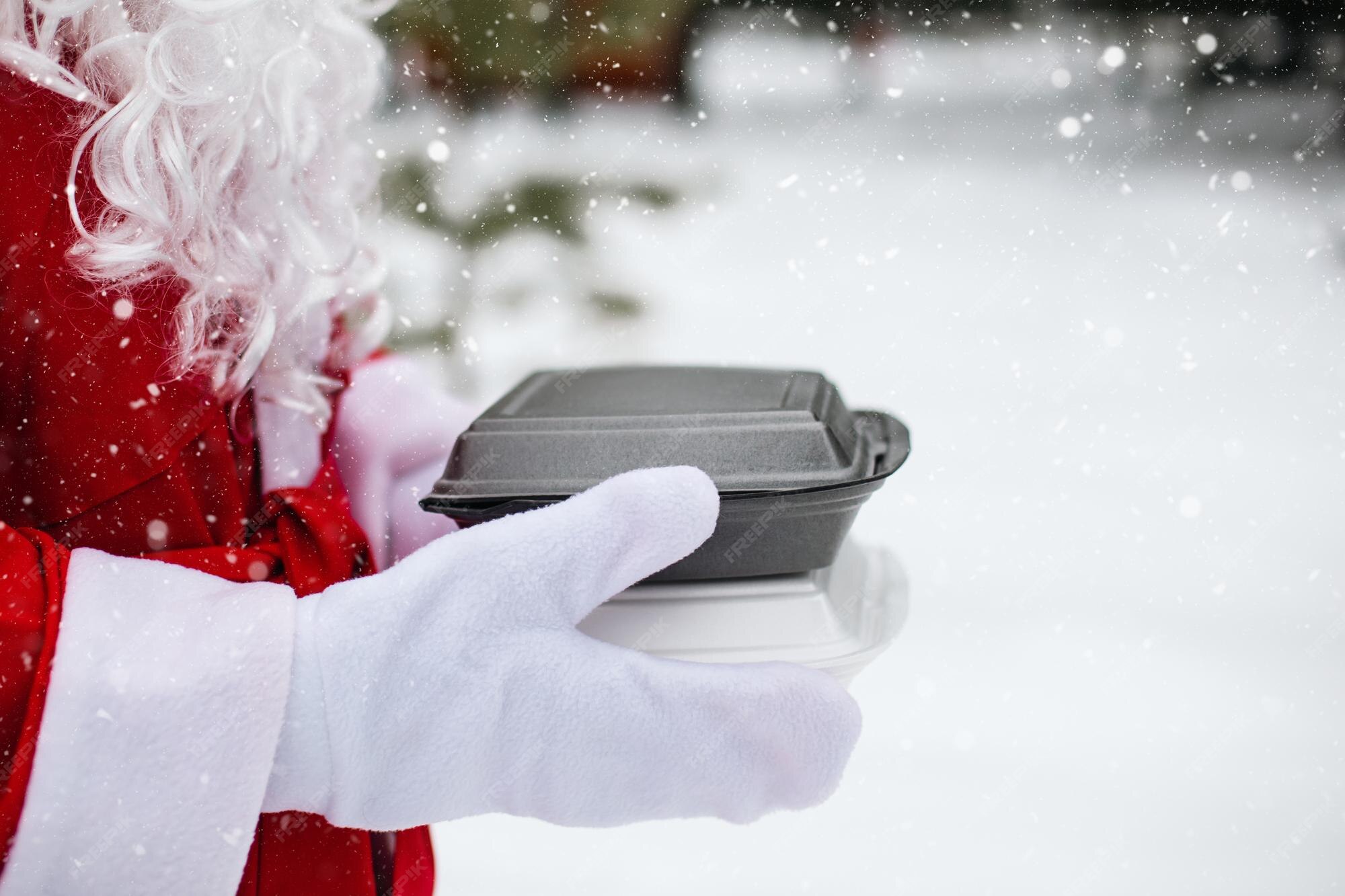 Premium Photo Food delivery service containers in hands of Santa
