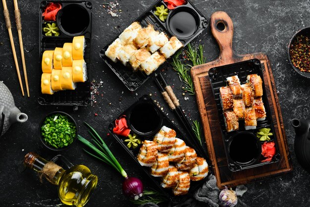 Consegna del cibo set di involtini di sushi con pesce, formaggio e salse cibo tradizionale giapponese vista dall'alto