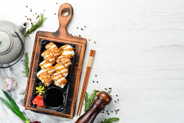 Consegna del cibo sushi con wasabi di tonno e salsa di soia in una scatola di plastica vista dall'alto