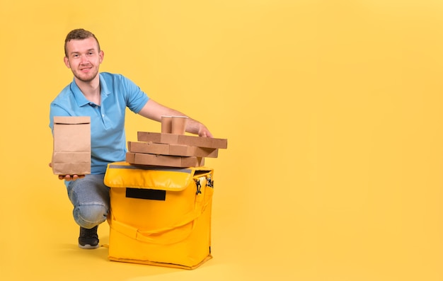 Food delivery young man in a blue t-shirt