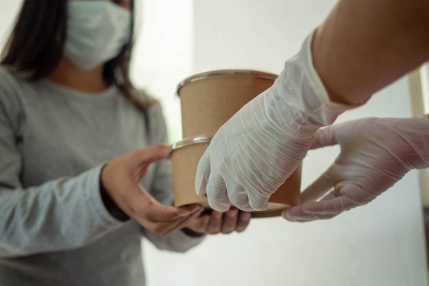 The food deliveryman wearing gloves carries a food box send to customers at home During the outbreak of COVID 19