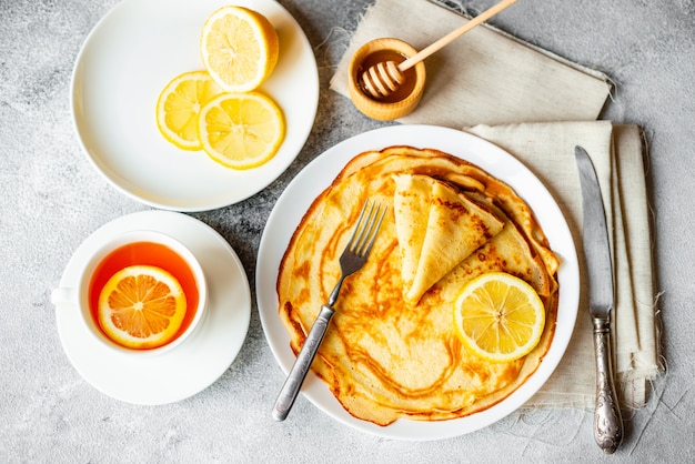 Food, dessert, pastries, pancake, pie. Tasty beautiful pancakes with banana and honey on a concrete background