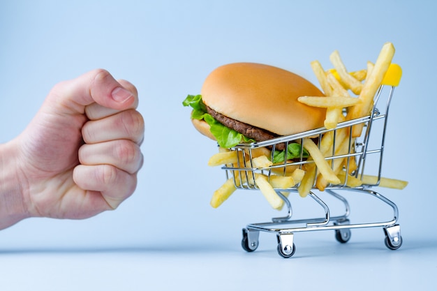 Foto concetto di cibo e dieta. patatine fritte e hamburger per merenda. combattere il sovrappeso e l'obesità. rifiuto di cibo spazzatura e malsano