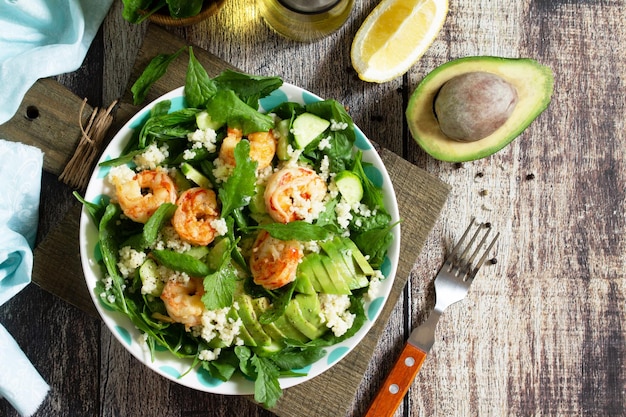 Food dieting concept Couscous salad with arugula avocado and grilled shrimps Top view Copy space